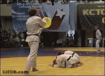 Man In Karate Uniform Holding Yellow Frisbee With ICT Sign GIF