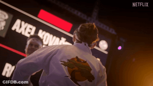 Man In Karate Uniform In Front Of Netflix Sign GIF
