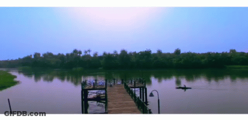 Man In Kayak Floating Near Dock GIF