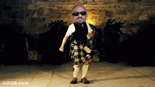 Man In Kilt Dancing In Front Of Brick Wall GIF