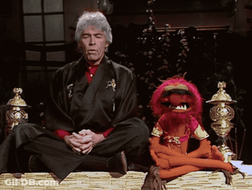 Man In Kimono In Lotus Position With Stuffed Animal GIF
