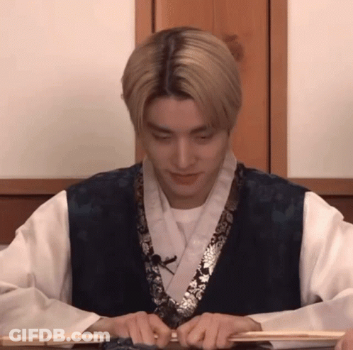 Man In Kimono Sitting At Table With Stick GIF