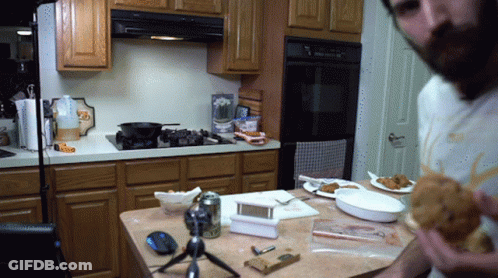 Man In Kitchen Eating Fried Chicken Sandwich GIF