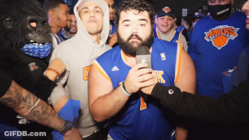 Man In Knicks Jersey Holding Microphone In Front Of Crowd GIF