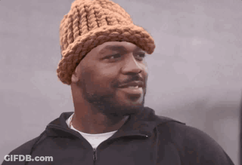 Man In Knitted Hat And Black Jacket Looking At Camera GIF