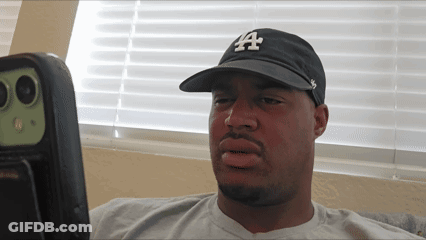 Man In LA Hat Looking At Something GIF