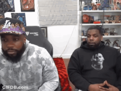 Man In LA Hat Next To Man In Black Hoodie GIF