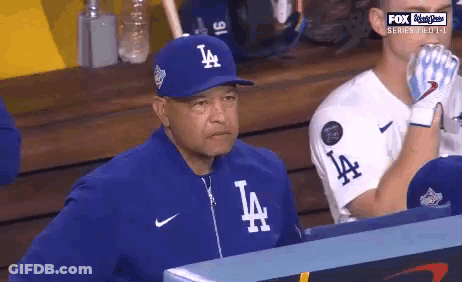 Man In LA Hat Watching Baseball In Dugout GIF