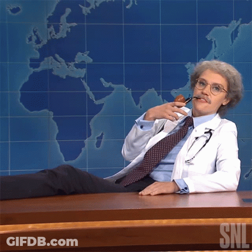 Man In Lab Coat At Desk With SNL Logo GIF