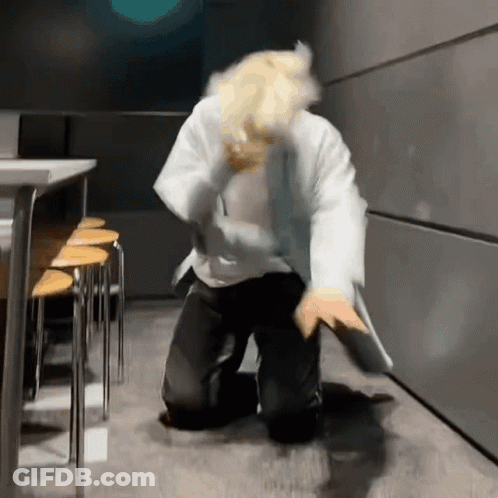 Man In Lab Coat Kneeling In Dark Room GIF