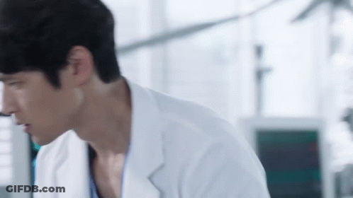 Man In Lab Coat Looking Down GIF