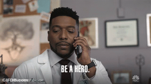 Man In Lab Coat On Cell Phone Saying Be A Hero GIF