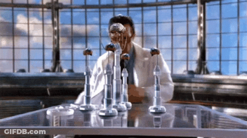Man In Lab Coat Sitting At Table GIF
