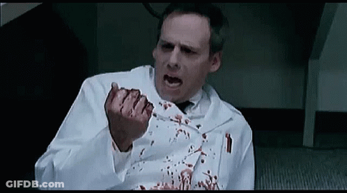Man In Lab Coat Sitting With Bleeding Fingers GIF