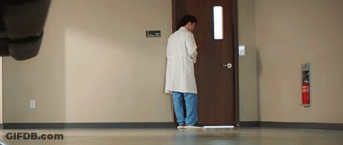 Man In Lab Coat Standing In Front Of Hospital Door GIF