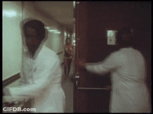 Man In Lab Coat Standing In Hallway GIF