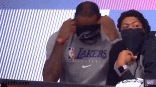 Man In Lakers Shirt Sitting With Masked Man GIF