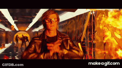 Man In Leather Jacket And Glasses Standing Before Fire GIF