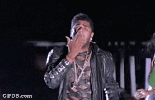 Man In Leather Jacket And Necklaces Making Funny Face In Dark GIF