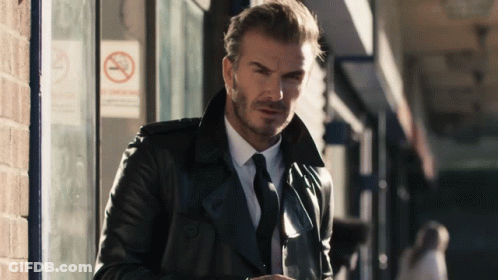 Man In Leather Jacket And Tie At No Smoking Sign GIF