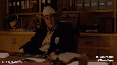 Man In Leather Jacket At Desk Saying In The Flesh GIF