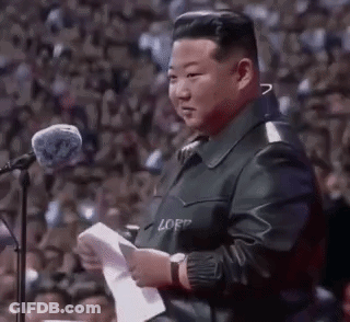 Man In Leather Jacket At Microphone Holding Paper GIF