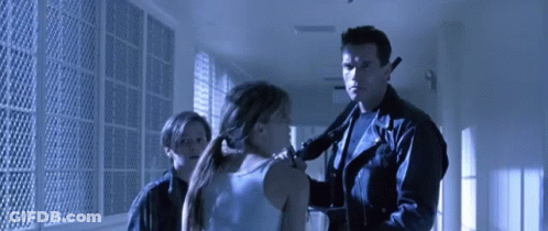 Man In Leather Jacket Holding Gun Next To Woman And Boy GIF