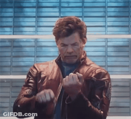 Man In Leather Jacket In Front Of Blue Wall GIF
