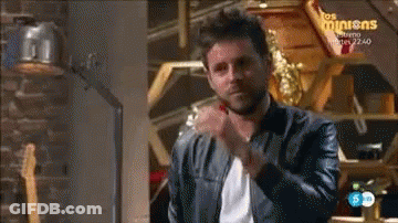 Man In Leather Jacket In Front Of Los Minions Sign GIF