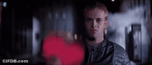 Man In Leather Jacket In Front Of Red Heart GIF