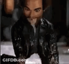 Man In Leather Jacket Kneeling And Eating GIF