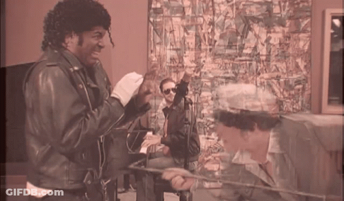 Man In Leather Jacket Next To Man In White Hat GIF