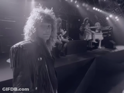 Man In Leather Jacket On Stage With Piano Player GIF
