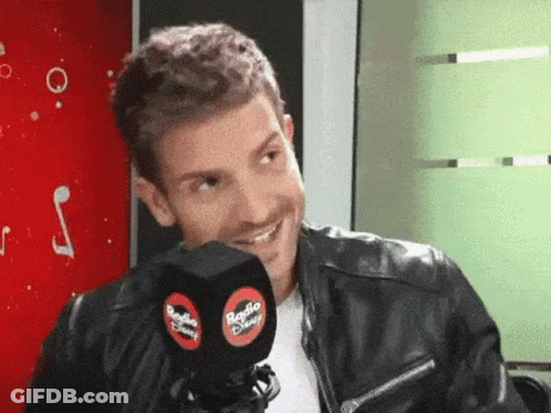 Man In Leather Jacket Smiling Holding Radio Disney Microphone GIF