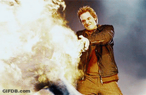 Man In Leather Jacket Standing By Fire GIF