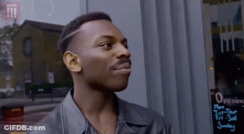 Man In Leather Jacket Standing In Front Of Opening Hours Sign GIF