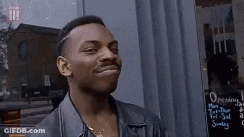 Man In Leather Jacket Standing In Front Of Opening Sign GIF