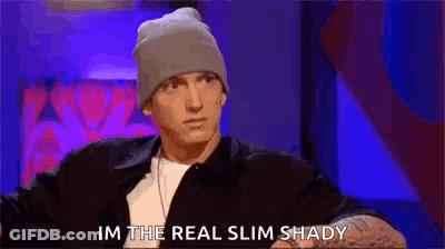 Man In Leather Jacket Waving On Couch GIF
