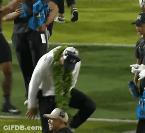 Man In Lei Kneeling On Football Field GIF