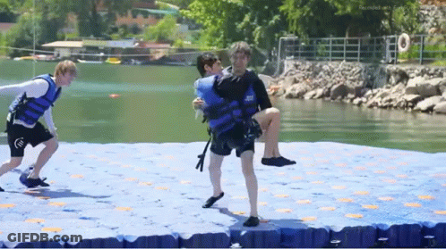 Man In Life Jacket Carrying Another Man On Raft GIF