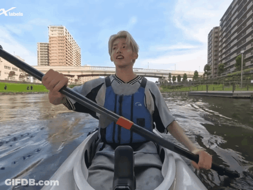 Man In Life Vest Paddling Kayak With X Labels Logo GIF