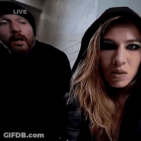 Man In Live Hat Next To Hooded Woman GIF