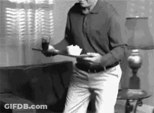 Man In Living Room Holding Tray With Food GIF