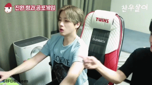 Man In Loewe Shirt Sitting In Twins Chair GIF