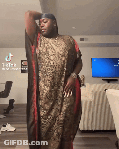 Man In Long Dress In Front Of TV With Tik Tok Sign GIF