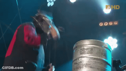 Man In Long Nose Mask Playing Drums In Front Of HD Keg GIF