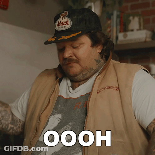 Man In Mack Trucks Hat And Vest Saying Oooh GIF