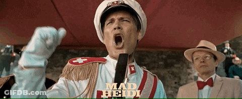 Man In Mad Heidi Costume Yelling Into Microphone GIF