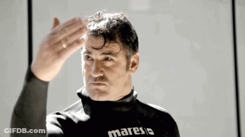 Man In Maresia Wet Suit Hand On Forehead GIF