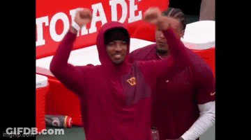 Man In Maroon Hoodie Standing Before Gatorade Sign GIF